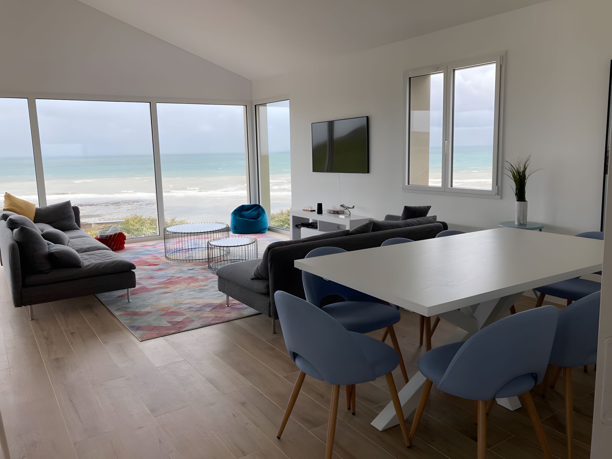 Salon et salle à manger avec baies vitrées face à la Manche